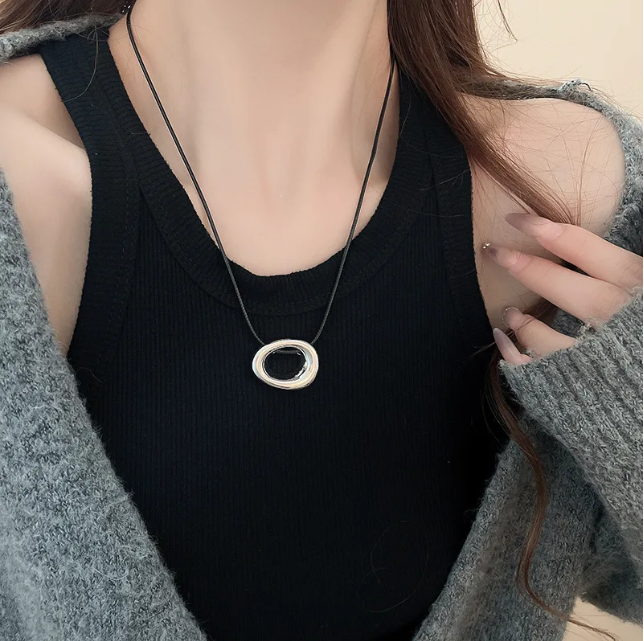 Punk style U-shaped pendant necklace with a horseshoe design on an adjustable leather rope. Unisex and perfect as a bold sweater chain.