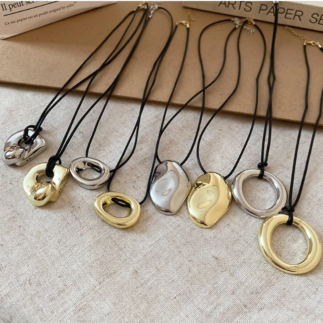 Punk style U-shaped pendant necklace with a horseshoe design on an adjustable leather rope. Unisex and perfect as a bold sweater chain.